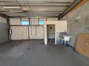 Garage featuring concrete block wall and a sink