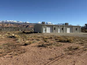 View of front facade with an outbuilding, a mountain view, and a workshop