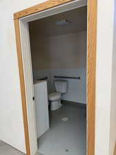 Bathroom featuring concrete floors and toilet