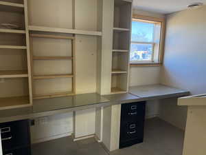 Unfurnished office with built in study area and baseboards