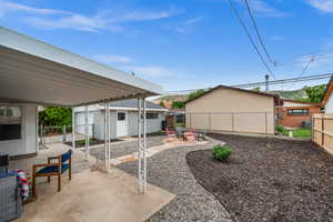 View of patio / terrace featuring a fenced backyard, a gate, an outdoor structure, and a fire pit