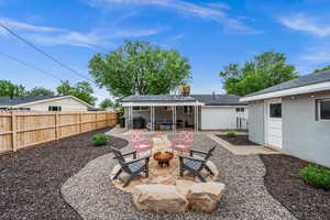 Fenced backyard featuring a fire pit and a patio