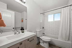 Full bath featuring toilet, shower / tub combo with curtain, and vanity