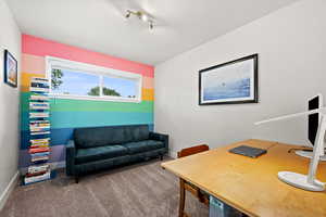 Carpeted office space with baseboards