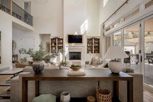 Living area featuring a high ceiling, wood finished floors, and built in shelves