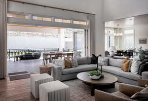 Living area featuring a chandelier, a towering ceiling, and wood finished floors