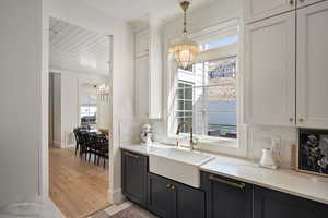 Kitchen featuring a sink, a chandelier, light countertops, tasteful backsplash, and light wood finished floors