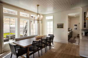 Dining room with light wood-style floors, a chandelier, baseboards, wood ceiling, and recessed lighting