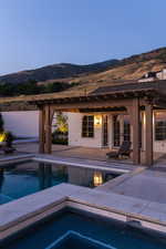 Swimming pool featuring a mountain view, an in-ground hot tub, a patio area, and french doors