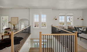 Stairs featuring wood finished floors, plenty of natural light, a textured ceiling, and recessed lighting