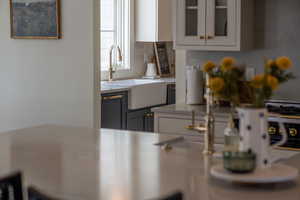 Kitchen with a sink, decorative backsplash, light countertops, glass insert cabinets, and white cabinetry
