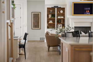 Living room with baseboards, wood finished floors, and a fireplace
