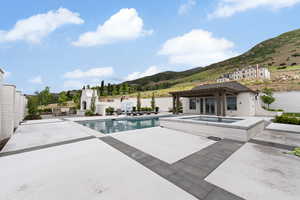 View of pool featuring an in-ground hot tub, a mountain view, fence, a patio area, and a pergola