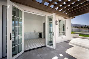 View of patio / terrace with a mountain view, beverage cooler, a pergola, and fence