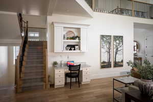 Living room with stairway, light wood-type flooring, and baseboards