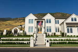 View of front of house with a mountain view, fence, and french doors