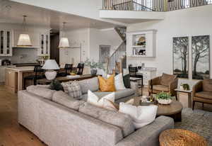 Living area featuring stairs, light wood-style floors, recessed lighting, wood ceiling, and a towering ceiling