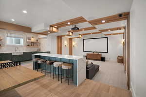 Cinema with a sink, light wood-style flooring, recessed lighting, and baseboards