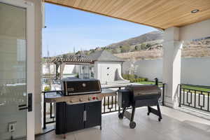 View of patio with a mountain view, a pergola, and fence