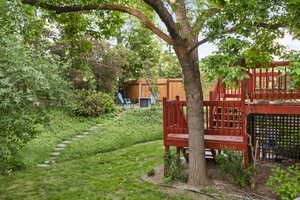 View of deck, stairs, and stone steps leading to second corner patio