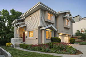 View of front of home with a 2 car garage, concrete driveway, stucco siding, and fence