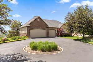 View of front of house featuring brick siding, driveway, a garage, and a shingled roof
