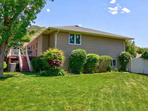 View of side of home with stairs and a wooden deck