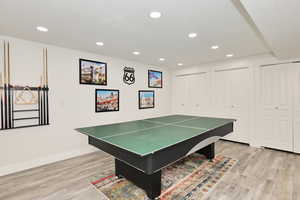 Recreation room with light wood-style flooring, recessed lighting, and baseboards