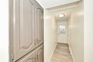 Hall with baseboards and light wood-type flooring