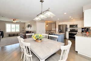 Dining space featuring ceiling fan, baseboards, wood finished floors, and recessed lighting
