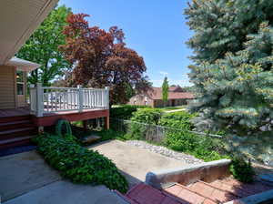 View of yard featuring a deck, a patio, and fence