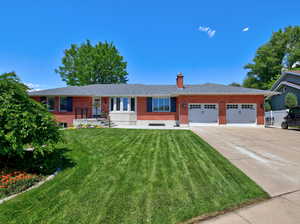 Ranch-style house with brick siding, a garage, driveway, and a front yard