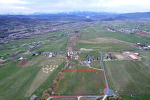 Aerial view of sparsely populated area featuring a mountainous background and property parcel outlined