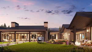 Back of property featuring a metal roof, a patio area, a chimney, a standing seam roof, and a lawn