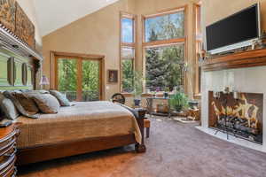 Bedroom with a high ceiling, carpet floors, and access to outside