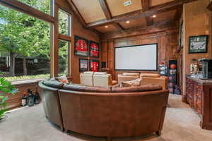 Cinema room with light colored carpet, beam ceiling, and coffered ceiling