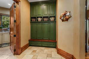 Mudroom with stone tile floors, baseboards, a sink, and recessed lighting