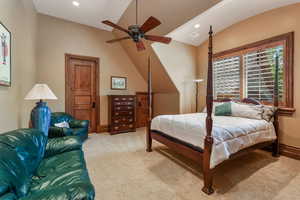 Carpeted bedroom featuring vaulted ceiling, recessed lighting, and a ceiling fan