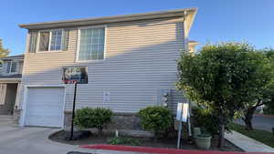View of side of property featuring an attached garage and driveway