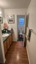 Bathroom with toilet, wood finished floors, vanity, and baseboards