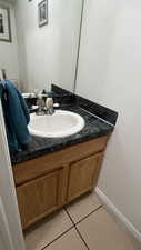 Bathroom featuring vanity, tile patterned floors, and baseboards