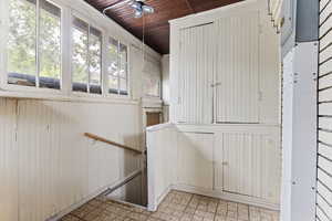 Staircase featuring wood ceiling, a ceiling fan, and wood walls