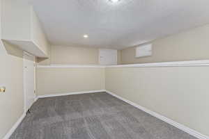 Finished below grade area featuring carpet, a textured ceiling, baseboards, and recessed lighting