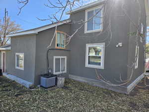 Back of property featuring central AC unit and stucco siding