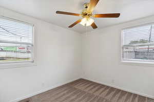 Spare room with carpet flooring, a ceiling fan, and baseboards