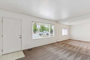Entryway featuring light colored carpet and baseboards