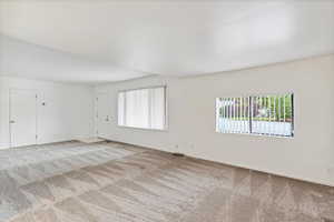 Empty room featuring light carpet and baseboards