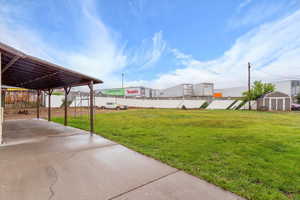 View of yard featuring a storage shed, an outdoor structure, and a patio