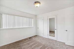 Unfurnished bedroom featuring carpet and baseboards
