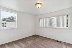 Carpeted spare room with baseboards